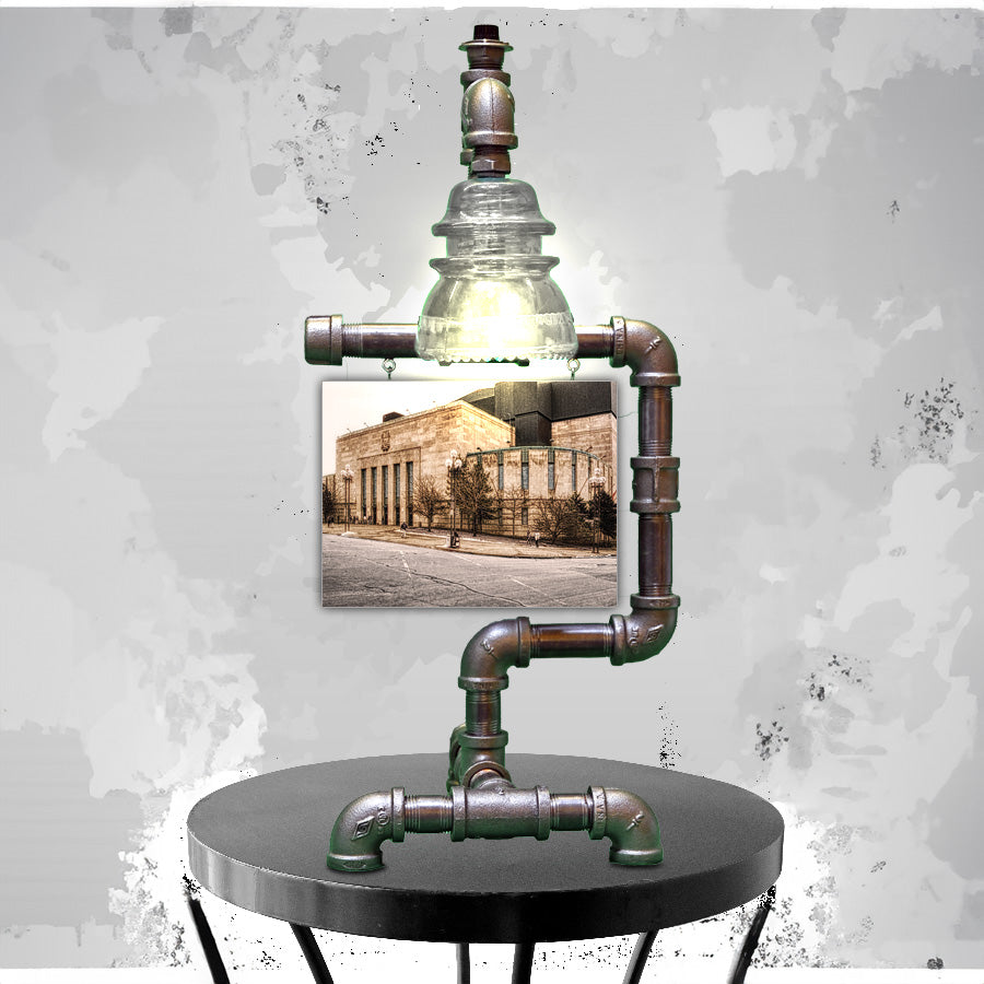 Buffalo Auditorium Lamp with steampunk pipe design and clear glass insulator light, featuring vintage Memorial Auditorium photo backdrop.