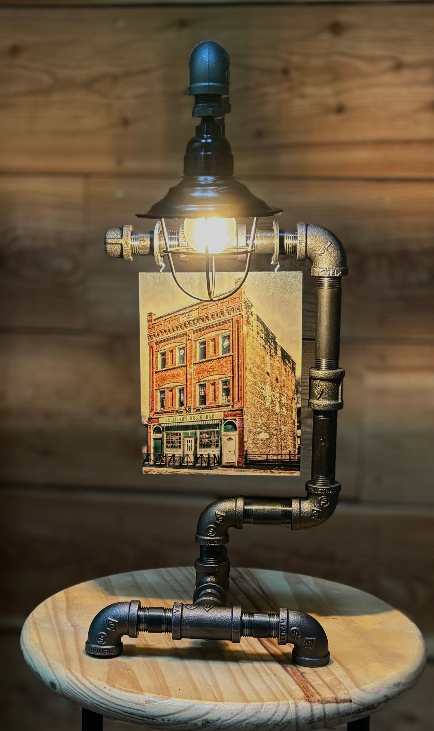 Mulligans Brick Steampunk Table Lamp with Edison light fixture, featuring industrial pipe design and vintage Buffalo building print. Ideal for rustic home decor.