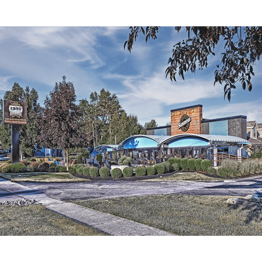 Santora's Pizza Pub Photos | Capture History & Tradition with a vibrant exterior view of the iconic Buffalo restaurant surrounded by lush greenery.