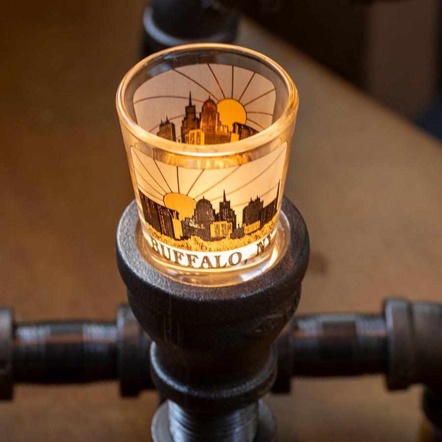 LED-lit Buffalo NY skyline shot glass on steampunk lamp base. Vintage industrial design perfect for nostalgic home lighting.
