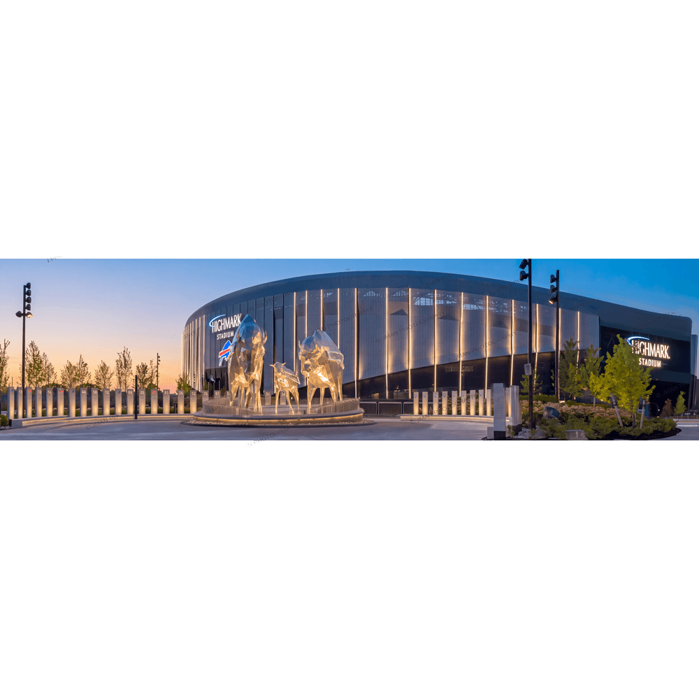 Highmark Stadium panorama photo art print showcasing the modern exterior with illuminated vertical lines and Buffalo Bills statues at dusk