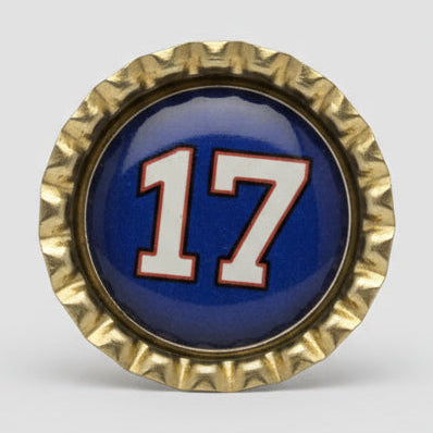 Decorative bottle cap with number '17' on a textured surface