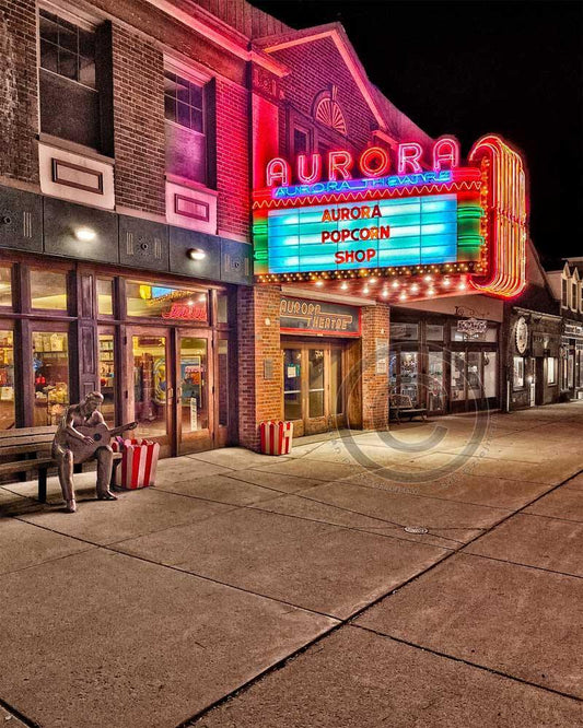 Nighttime photo of East Aurora Theatre marquee lit in neon, highlighting the Aurora Popcorn Shop and vintage street scene for rustic decor appeal.